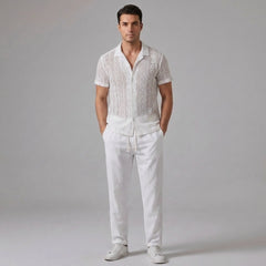 Man wearing a white geometry textured Cuban shirt and straight leg linen pants front view on plain background