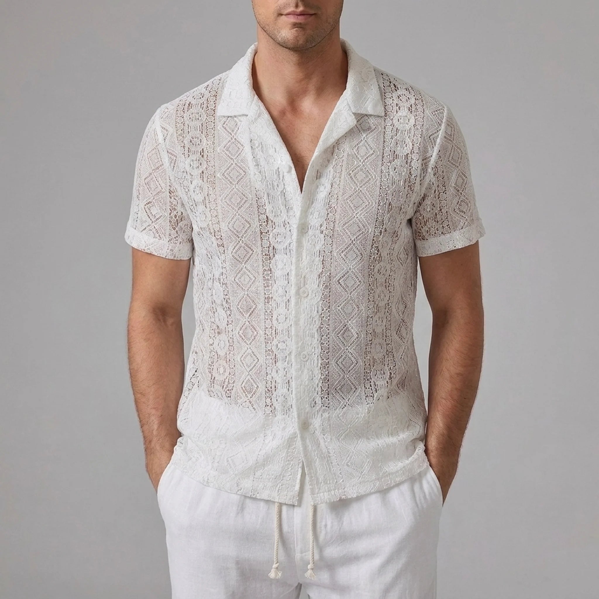 Side view of man in white geometry textured Cuban shirt and straight leg linen pants on plain background