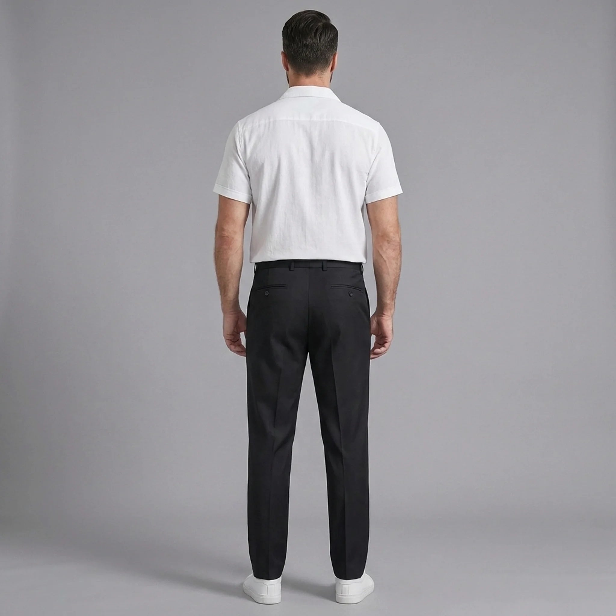 Back view of man wearing white linen Cuban collar shirt and slim fit tapered trousers