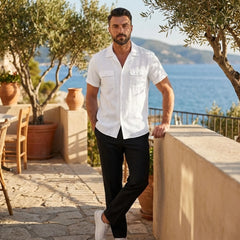 Man wearing white linen Cuban collar shirt and slim fit tapered trousers in outdoor lifestyle setting