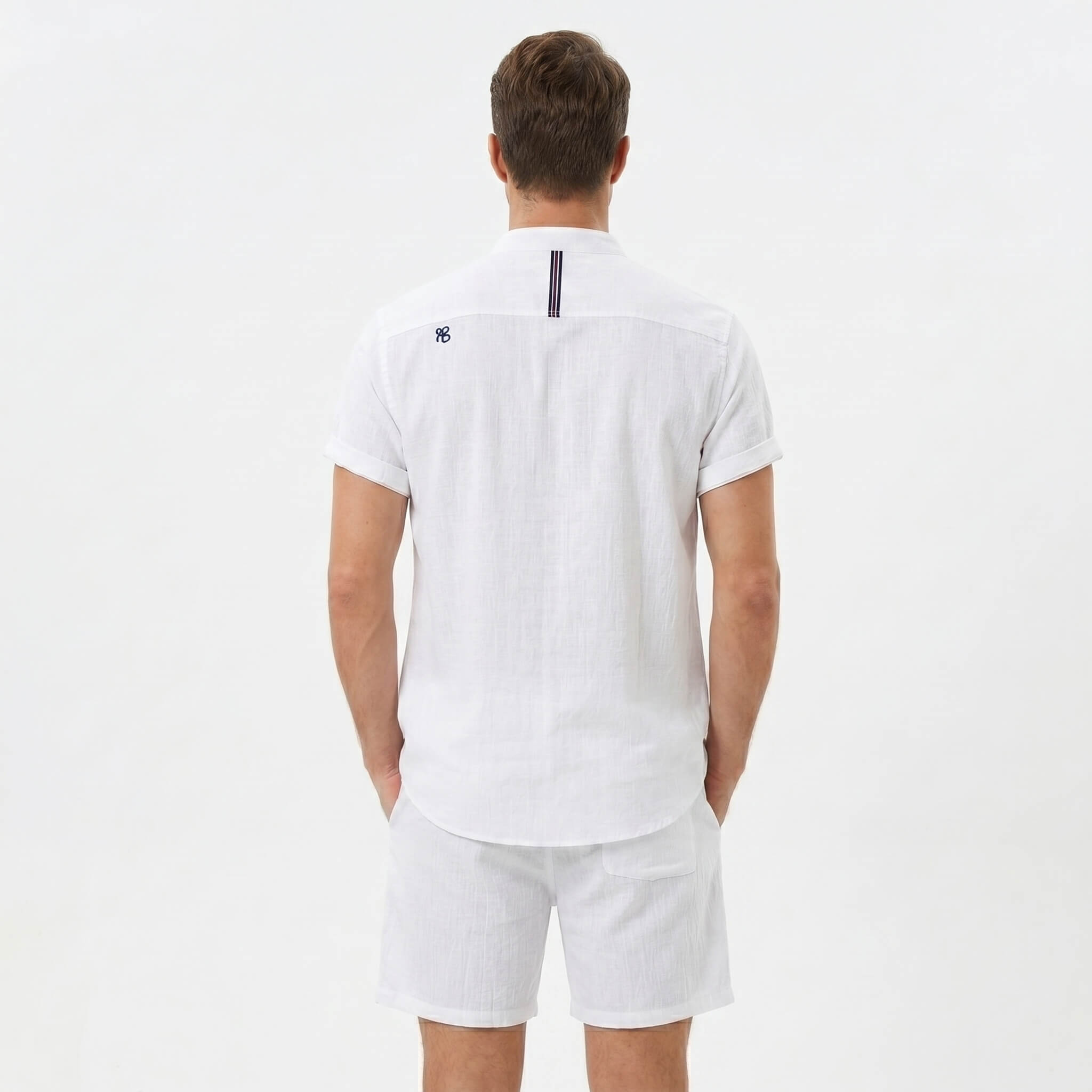 Back view of man wearing white linen look stand collar shirt and crinkle drawstring shorts