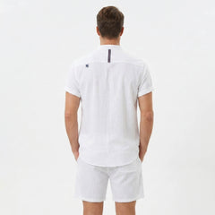 Back view of man wearing white linen look stand collar shirt and crinkle drawstring shorts