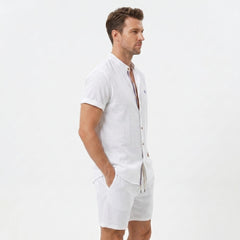 Side view of man in white linen look stand collar shirt and crinkle textured drawstring shorts