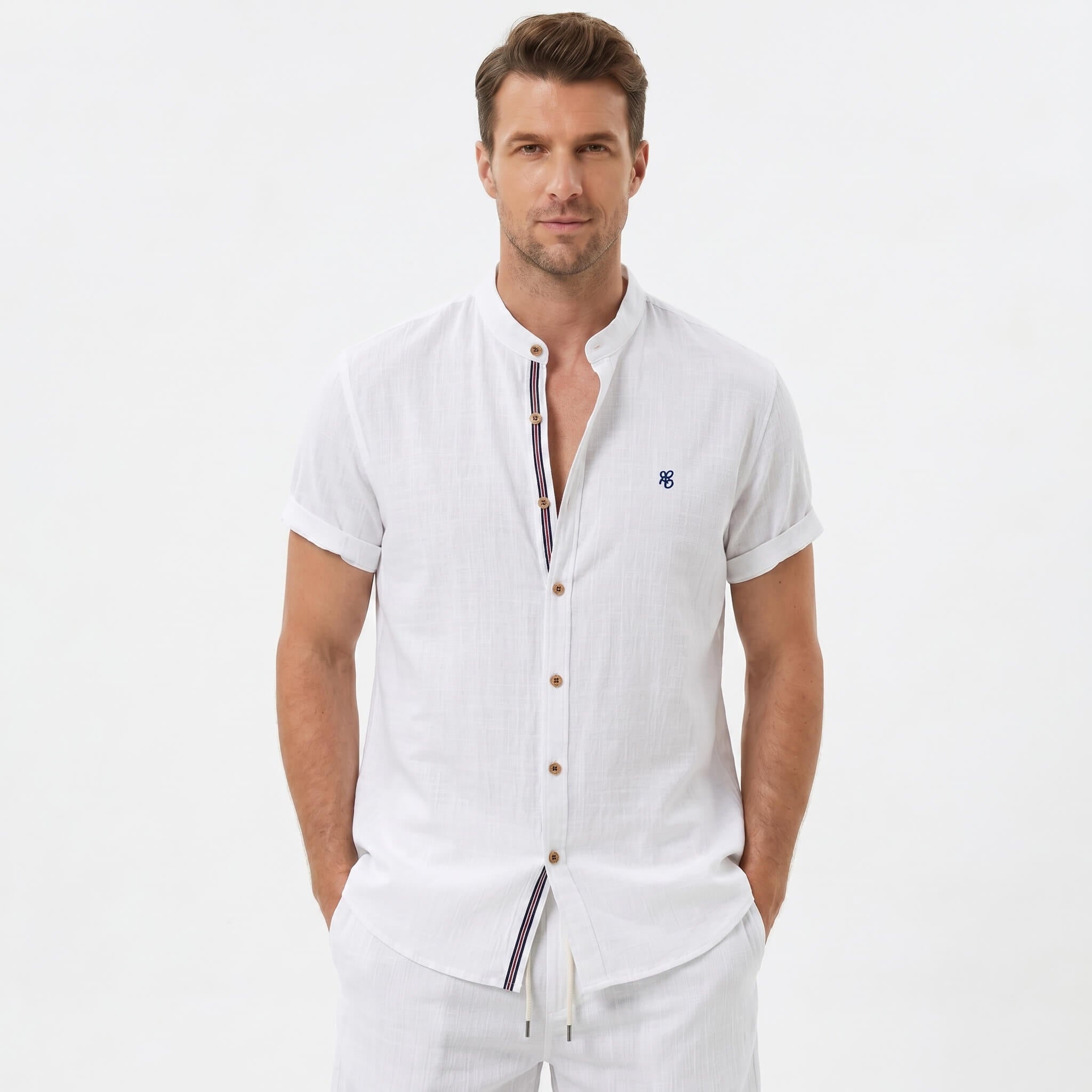 Three quarter view of man in white linen look stand collar shirt and crinkle drawstring shorts