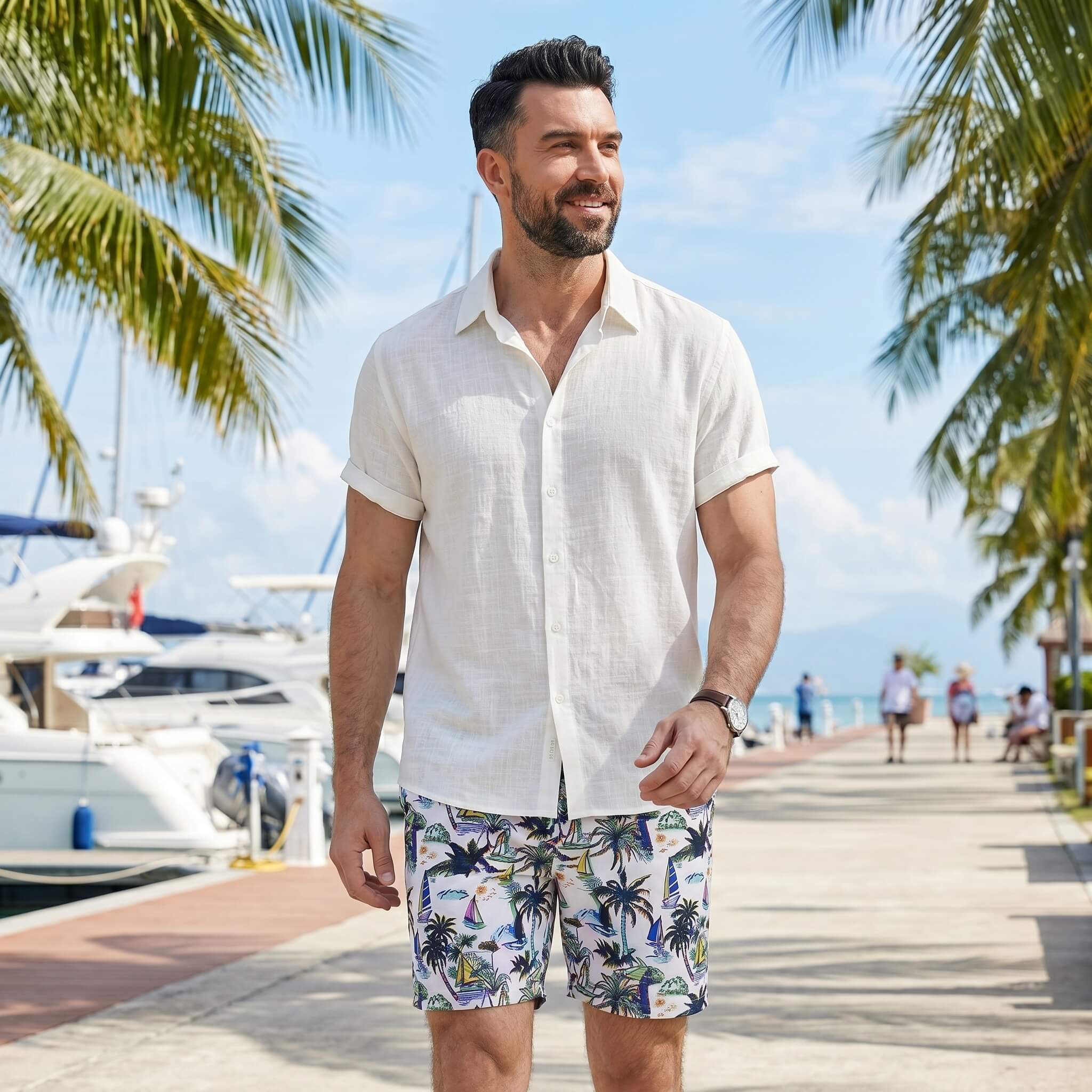 Man wearing white linen rayon shirt and white palm tree print swim shorts in outdoor lifestyle setting