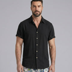 Man wearing white linen rayon shirt and white palm tree swim shorts relaxed outdoor lifestyle scene