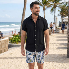 Man wearing white linen rayon shirt and white palm tree swim shorts in tropical outdoor lifestyle