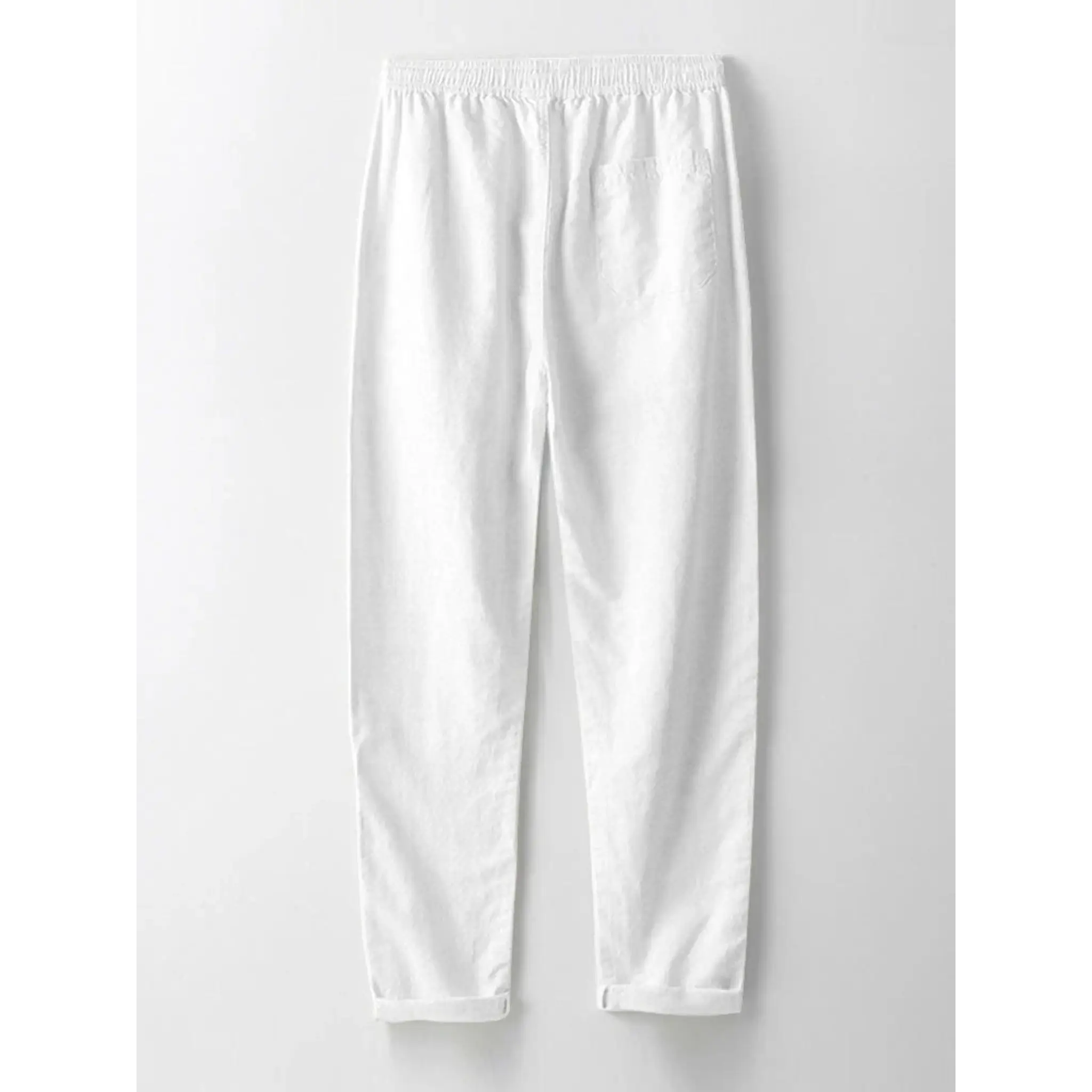 Back view of man wearing white and navy striped knit button up shirt and straight leg linen pants