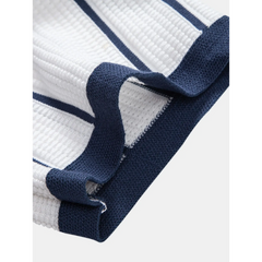 Full length view of man wearing white and navy striped knit shirt and straight leg linen pants on white background