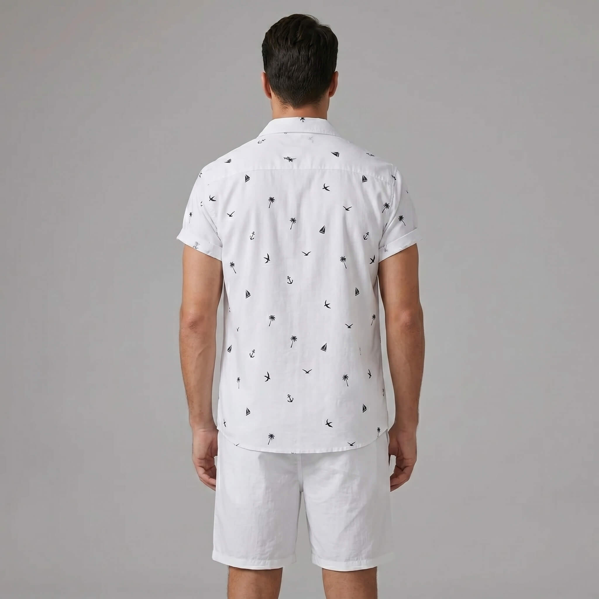 Back view of man wearing white palm tree anchor sailboat print shirt and swim shorts