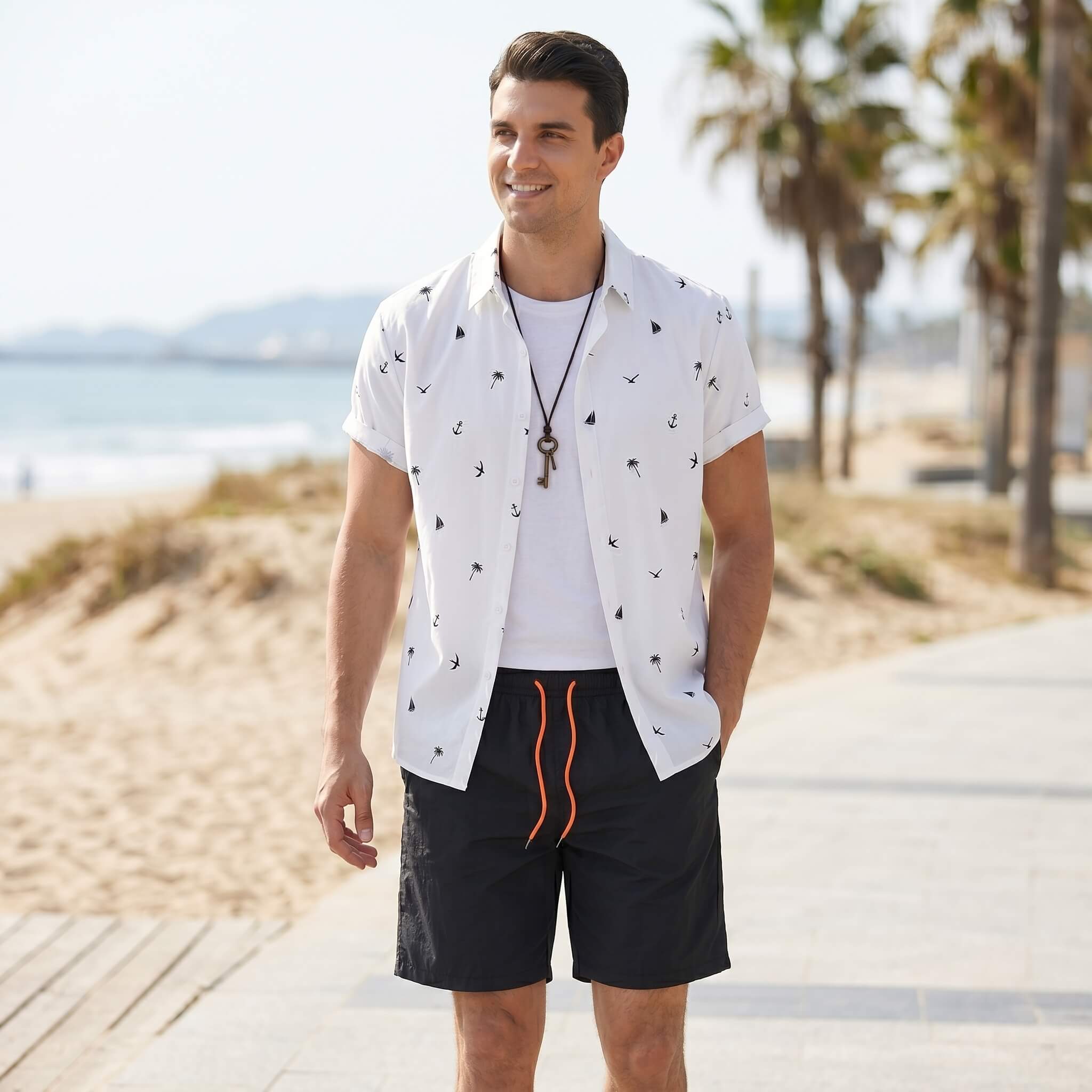 Man wearing white palm tree anchor sailboat print shirt and swim shorts in outdoor lifestyle setting