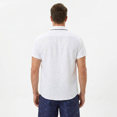 Back view of man wearing white palm tree print linen look cotton shirt and swim shorts