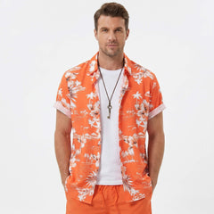 Man in white palm tree tropical print shirt and swim shorts walking along a sunny beach setting