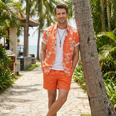 Man in white palm tree tropical print shirt and swim shorts at sunny beach boardwalk