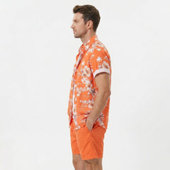 Three quarter view of man wearing white palm tree tropical print shirt and swim shorts outdoors