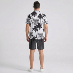Back view of man wearing white palm trees print button up shirt and striped swim shorts