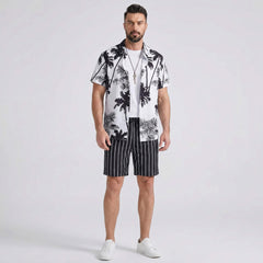 Man wearing a white palm trees print button up shirt and striped swim shorts front view on plain background