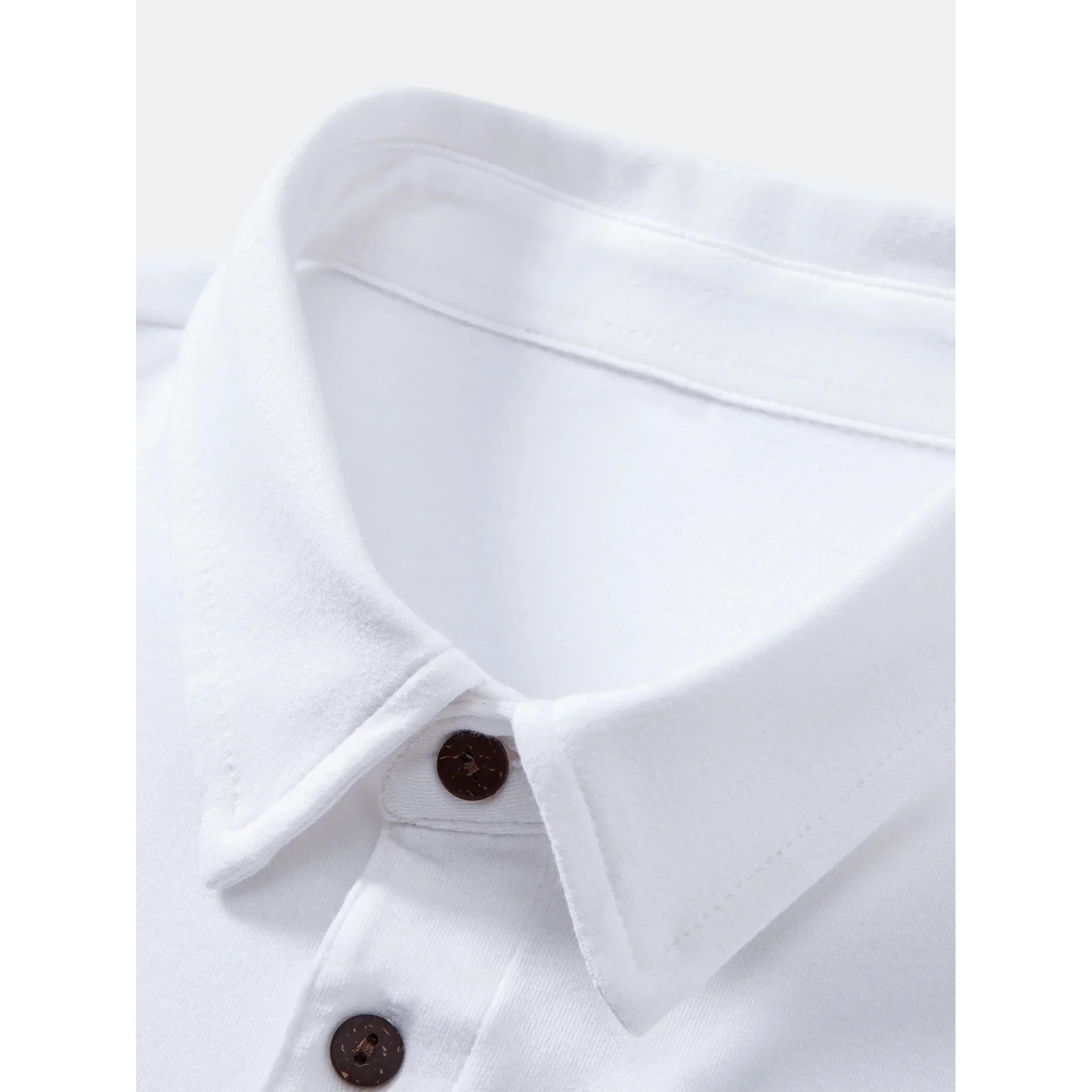 Man wearing black solid long sleeve cotton polo shirt in outdoor lifestyle setting
