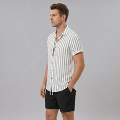Man wearing a white striped cotton blend button up shirt and crinkle textured drawstring shorts front view