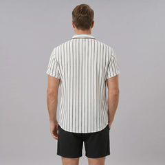 Side view of man in white striped cotton blend button up shirt and crinkle textured drawstring shorts