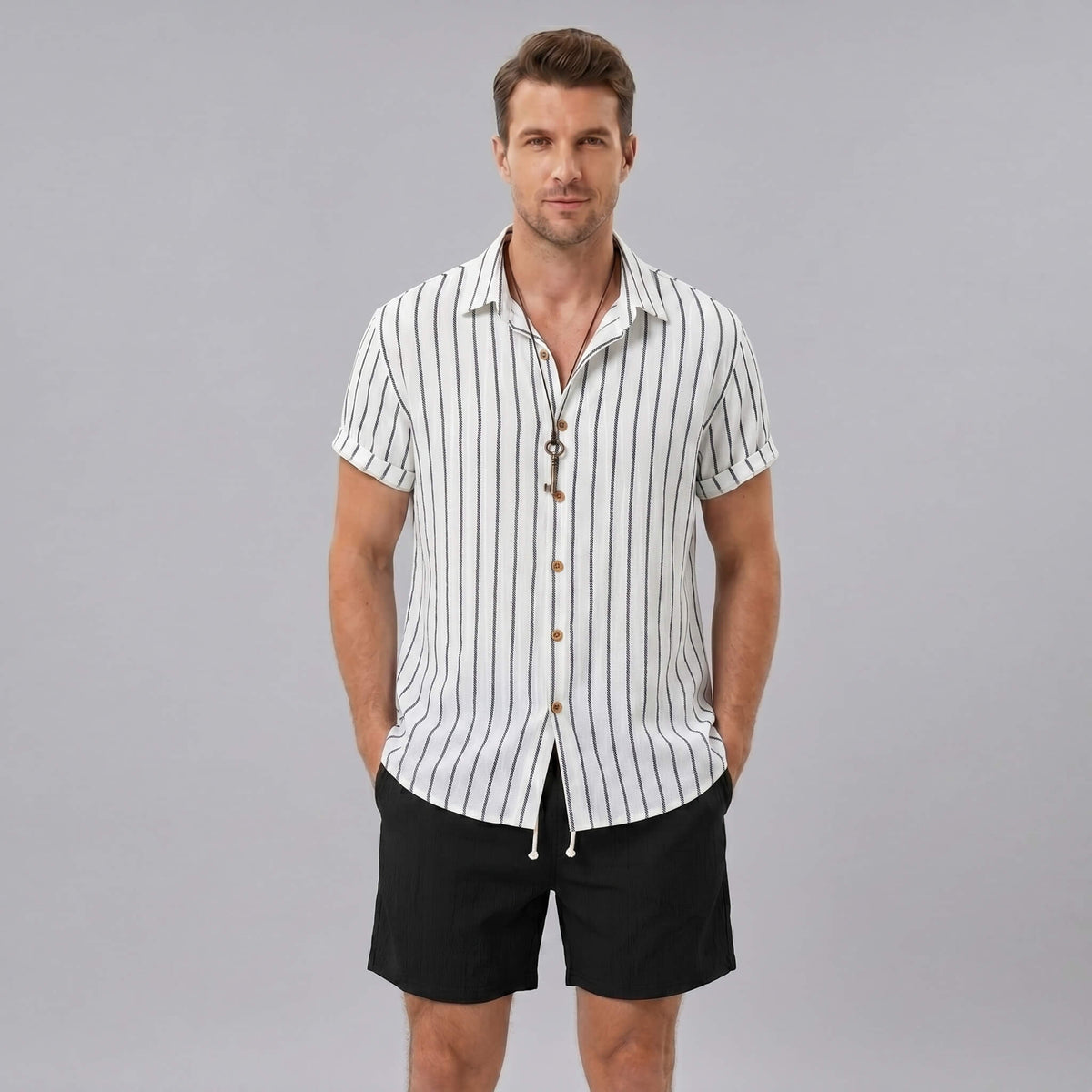 Man wearing a white striped shirt and black shorts on a gray background