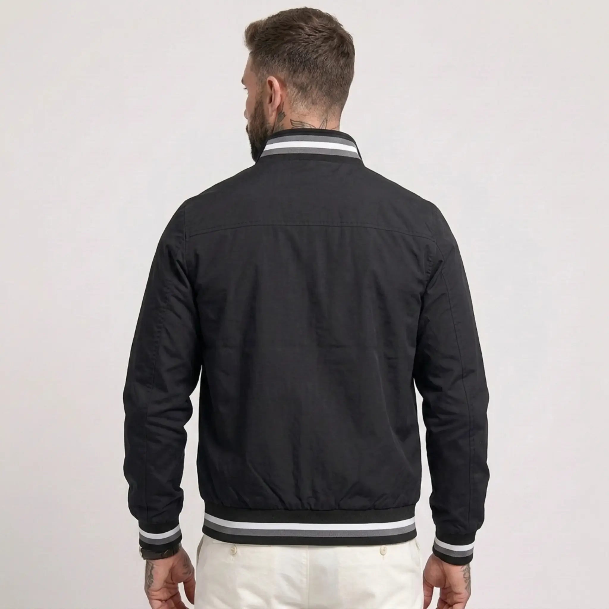 MannerCo black waterproof windbreaker jacket back view with striped collar and cuffs