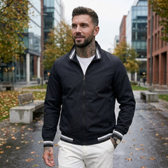 Man wearing MannerCo black waterproof windbreaker jacket in outdoor lifestyle setting