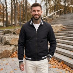 Man wearing MannerCo black waterproof windbreaker jacket in outdoor lifestyle setting