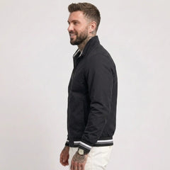 Man wearing MannerCo black waterproof windbreaker jacket with stand collar, side view