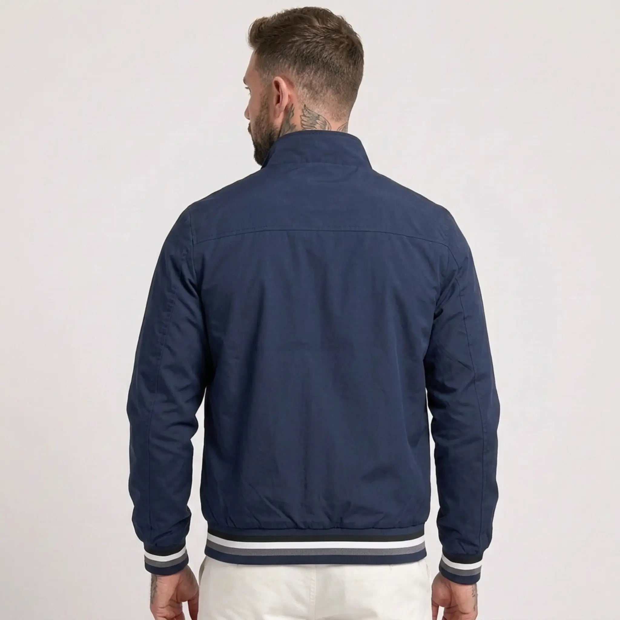 MannerCo dark blue waterproof windbreaker jacket back view with striped collar and cuffs