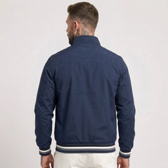 MannerCo dark blue waterproof windbreaker jacket back view with striped collar and cuffs