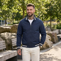 Man wearing MannerCo dark blue waterproof windbreaker jacket in outdoor lifestyle setting