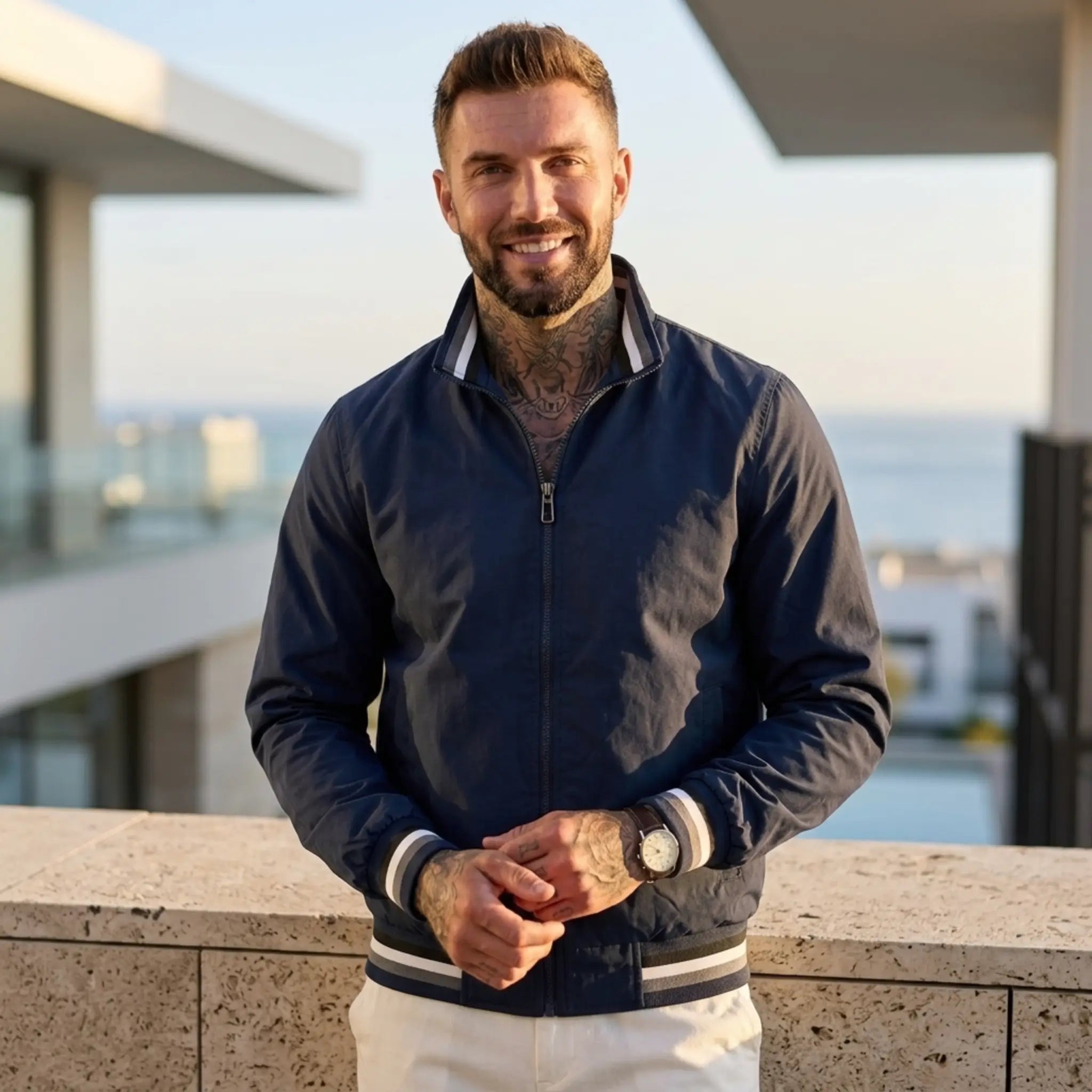 Man wearing MannerCo dark blue waterproof windbreaker jacket in outdoor lifestyle setting