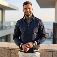 Man wearing MannerCo dark blue waterproof windbreaker jacket in outdoor lifestyle setting