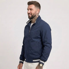 Man wearing MannerCo dark blue waterproof windbreaker jacket with stand collar, side view