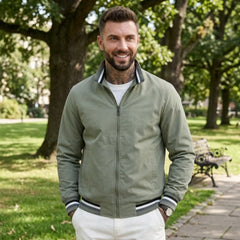 Man wearing MannerCo green waterproof windbreaker jacket in outdoor lifestyle setting
