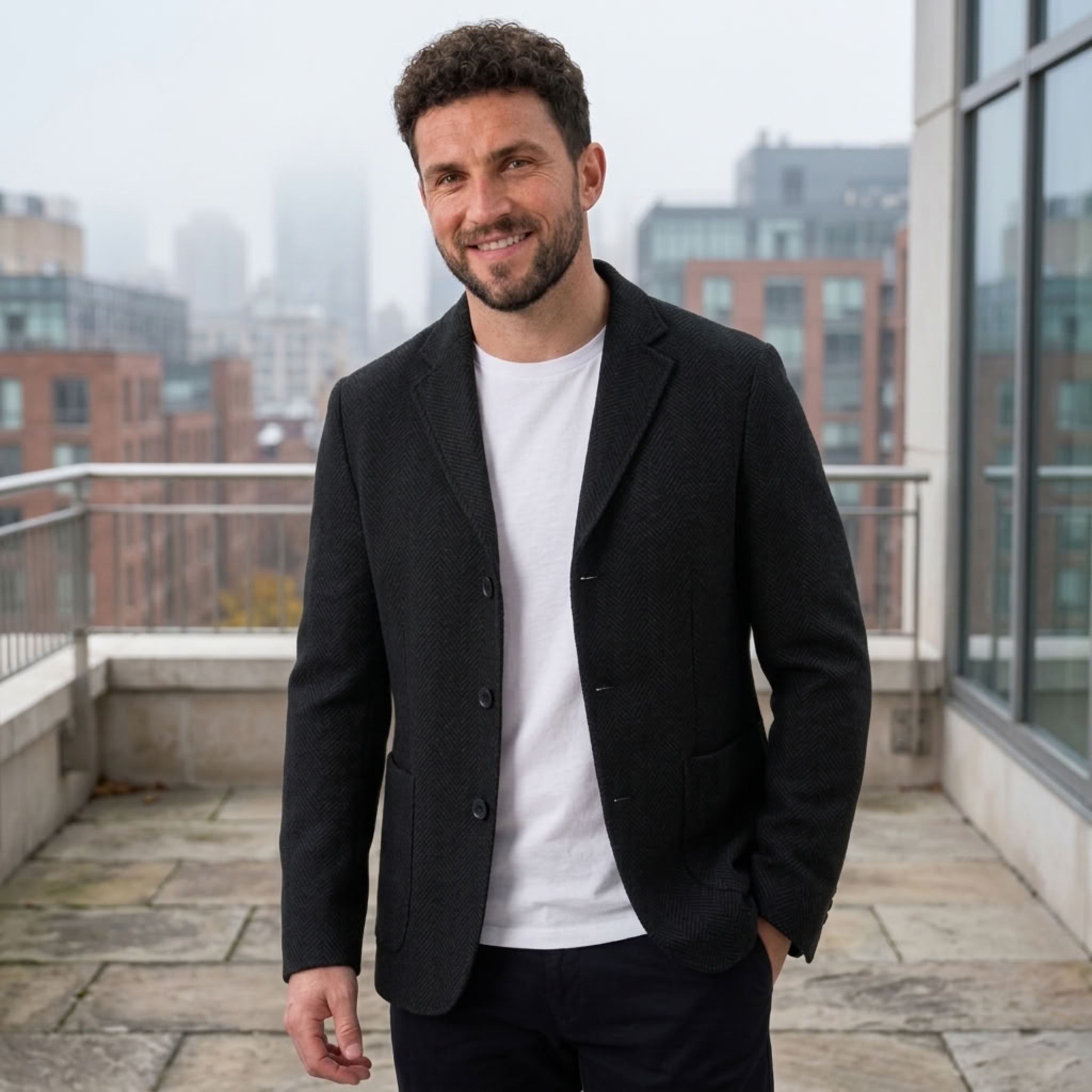 MannerCo black woolen blazer worn by man on city rooftop smart casual sport coat