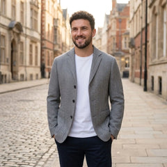 MannerCo gray woolen blazer with white tee and navy trousers on cobblestone street