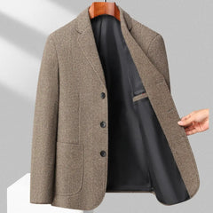 MannerCo khaki woolen blazer shown open to reveal black lining hung on wooden hanger